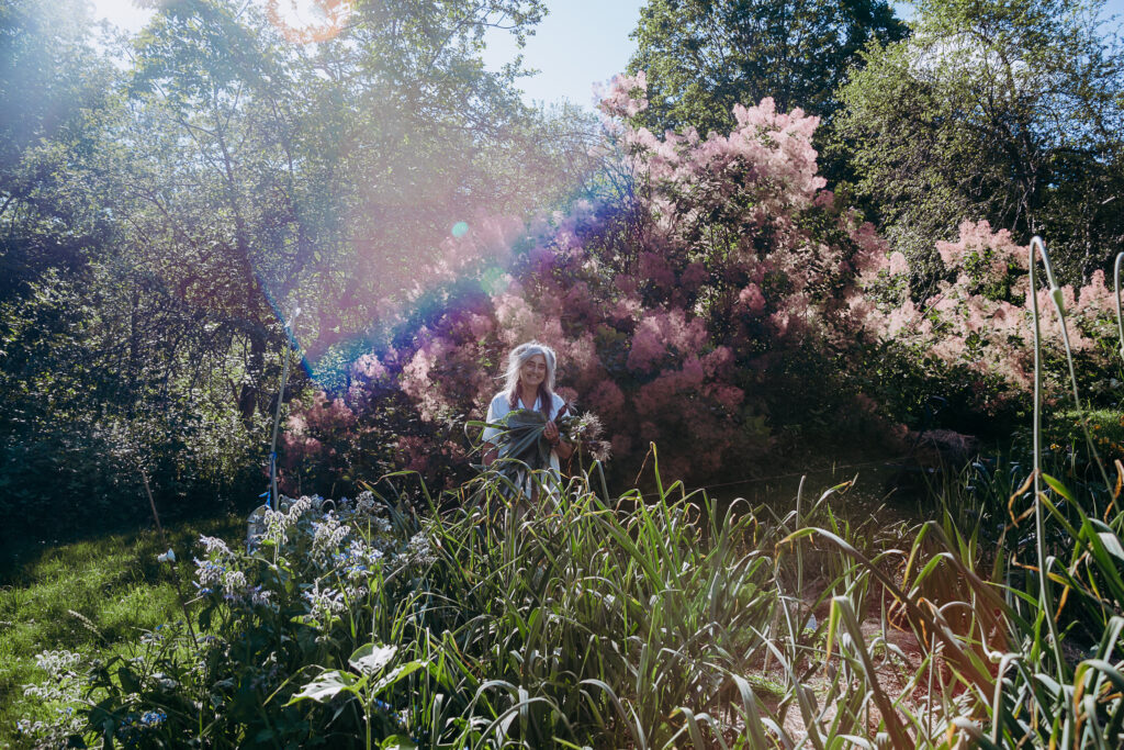 Woman Standing in Garden With Flowers in Bloom