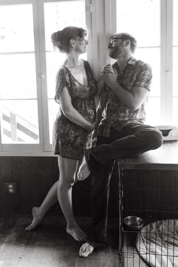 Pregnant Mom And Dad Looking Lovingly At One Another in Kitchen Black and White Photo