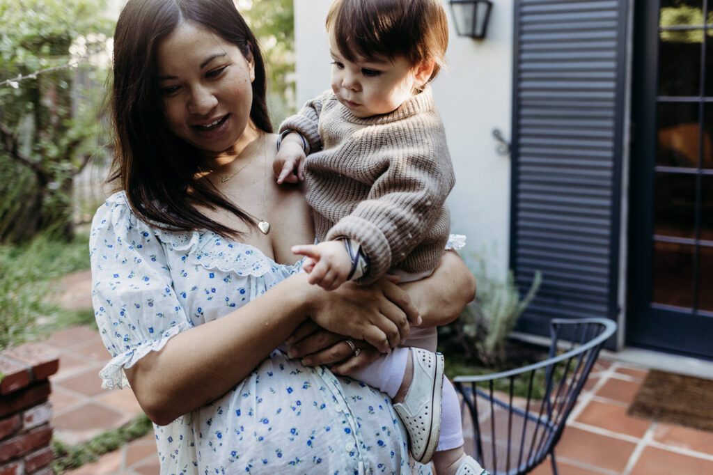 Pregnant mom holds her toddler in her arms