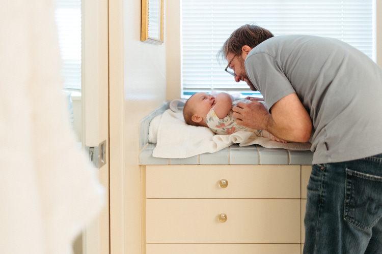 Dad changing baby's diaper ahead of wedding