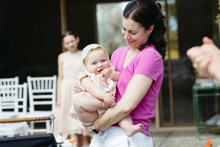 Woman in pink at wedding in Palm Springs holding baby